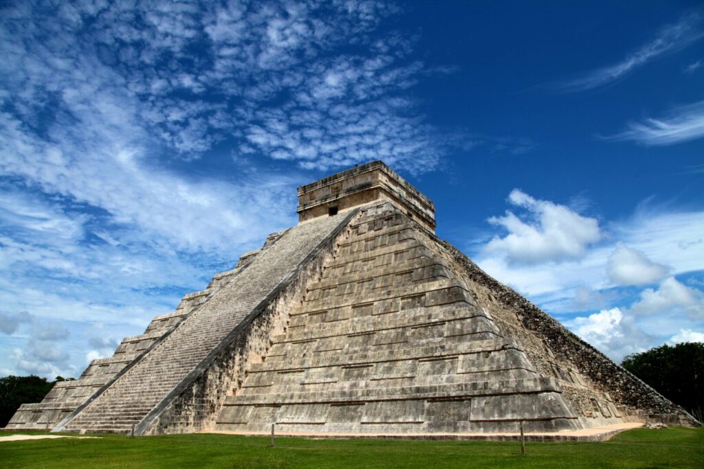 Chichen Itza, an ancient stone pyramid in Mexico in front of a rich blue sky