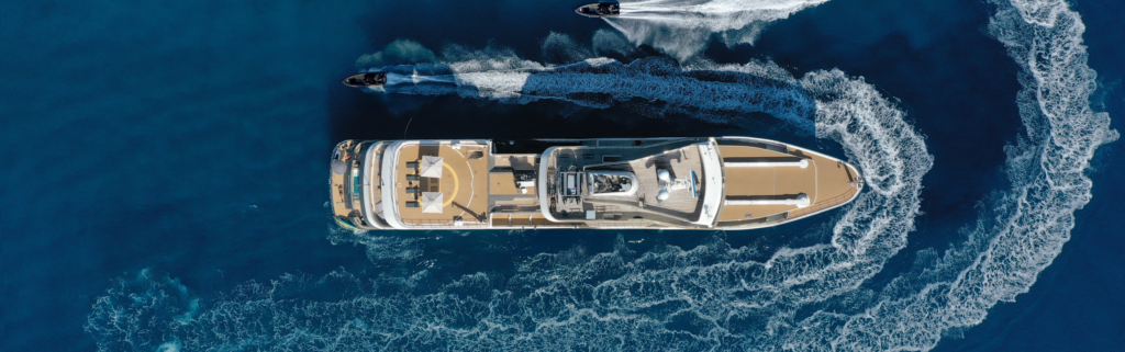 Ariel view of Aqua Lares Expedition Boat in a deep blue sea. water trails in picture.